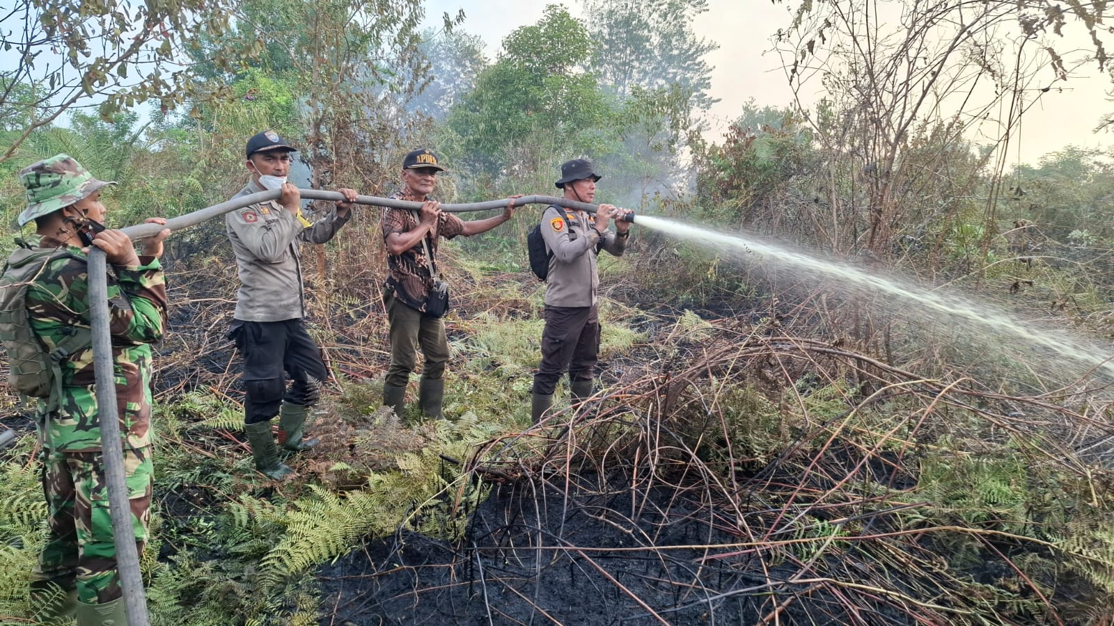 Tak Kenal Lelah, Kapolsek Kempas Bersama Tim Karhutla Lakukan Pemadaman dan Pendinginan